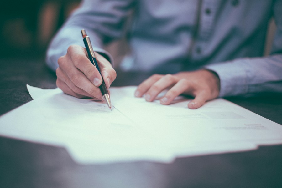 A person carefully reviewing and completing paperwork